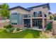 Spacious backyard featuring a patio, balcony, well-kept lawn, and inviting outdoor seating areas at 817 Backcountry Ln, Highlands Ranch, CO 80126