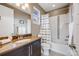 Clean bathroom with a large vanity, a framed mirror, and a shower-tub combo with decorative tile at 817 Backcountry Ln, Highlands Ranch, CO 80126