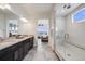 Modern bathroom features a dual sink vanity, luxurious shower, and views into the stylish bedroom at 817 Backcountry Ln, Highlands Ranch, CO 80126