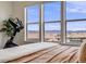 Comfortable bedroom features large windows with views of the neighborhood, beautiful bedding, and hardwood flooring at 817 Backcountry Ln, Highlands Ranch, CO 80126