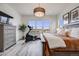 Bright bedroom showcases an exercise bike, large windows with neighborhood views, and luxury wood flooring at 817 Backcountry Ln, Highlands Ranch, CO 80126