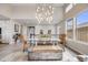 Bright dining area with a glass table, wicker chairs, modern light fixture, and wood-look tile flooring at 817 Backcountry Ln, Highlands Ranch, CO 80126