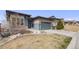 Stylish single-story house with a two-car garage, modern details, tidy landscaping, and partial grass at 817 Backcountry Ln, Highlands Ranch, CO 80126