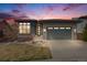 Charming single-story home with a manicured lawn, a stone garden, and a gray two-car garage door at 817 Backcountry Ln, Highlands Ranch, CO 80126