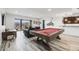 Spacious game room with a pool table, bar area, stylish furniture, and sliding glass doors to the outside at 817 Backcountry Ln, Highlands Ranch, CO 80126