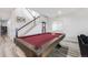 Bright game room with a wooden pool table, staircase, and neutral walls accented by art at 817 Backcountry Ln, Highlands Ranch, CO 80126