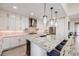 Modern kitchen features a large island with pendant lighting, white cabinetry and stainless steel appliances at 817 Backcountry Ln, Highlands Ranch, CO 80126