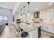 Modern kitchen features a large island with pendant lighting, white cabinetry and stainless steel appliances at 817 Backcountry Ln, Highlands Ranch, CO 80126