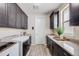 Well-organized laundry room with dark cabinetry, ample counter space, and modern appliances at 817 Backcountry Ln, Highlands Ranch, CO 80126