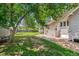 View of the spacious backyard, featuring mature trees and a partially shaded lawn at 4001 S Acoma St, Englewood, CO 80110