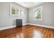 Bright bedroom featuring hardwood floors, neutral paint, and large windows at 4001 S Acoma St, Englewood, CO 80110