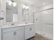 Well-lit bathroom with double vanity, framed mirrors, and a glass-enclosed shower at 4113 Marble Dr, Mead, CO 80504