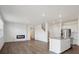 Open-concept living room with hardwood floors, electric fireplace and kitchen island at 4113 Marble Dr, Mead, CO 80504