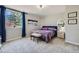 Bright bedroom with a plush bed, accent bench, and a large window with blue curtains letting in natural light at 4781 Mariposa Rd, Castle Rock, CO 80104