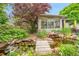 Lush backyard with a serene pond, featuring a small wooden bridge and vibrant greenery at 5323 E Sandpiper Ave, Castle Rock, CO 80104