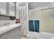 Clean bathroom with a gray vanity, framed mirror, decorative shower curtain, and modern glass shower doors at 5323 E Sandpiper Ave, Castle Rock, CO 80104