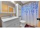 Cozy bathroom featuring a white vanity, framed mirror, and a shower with a decorative blue floral curtain at 5323 E Sandpiper Ave, Castle Rock, CO 80104
