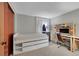 Bright bedroom with a full-size bed with storage underneath, a work desk, and neutral-toned walls at 5323 E Sandpiper Ave, Castle Rock, CO 80104
