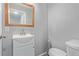 Bathroom with white sink vanity, wood-framed mirror, toilet, gray walls, and light gray flooring at 778 2Nd St, Firestone, CO 80520