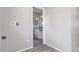 Hallway view towards bathroom featuring gray walls, wood-look floors, and a glimpse into the bathroom at 778 2Nd St, Firestone, CO 80520