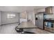 Spacious open-concept kitchen area featuring stainless steel appliances, island seating, and light gray walls at 778 2Nd St, Firestone, CO 80520
