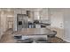 Well-lit kitchen featuring stainless steel appliances, a gray countertop island with seating, and white cabinetry at 778 2Nd St, Firestone, CO 80520