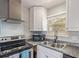 Close-up of kitchen featuring stainless steel oven, microwave, white cabinets, and double sink with window views at 778 2Nd St, Firestone, CO 80520