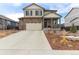 Two-story home featuring a two-car garage, stone accents, covered porch, and well-maintained landscaping at 9 N Waterloo St, Aurora, CO 80018