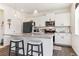 Modern kitchen featuring white cabinets, stainless steel appliances, granite countertops, and bar stool seating at 9 N Waterloo St, Aurora, CO 80018