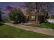 Charming brick home with a well-manicured lawn and mature tree at dusk at 805 S Everett St, Lakewood, CO 80226