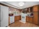 Bright kitchen featuring white appliances, vintage wood cabinets, and view to backyard at 805 S Everett St, Lakewood, CO 80226