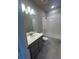 Bathroom with white tile shower over tub and gray cabinets at 2277 Serenidad St, Brighton, CO 80601