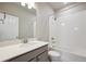 Bathroom featuring a tub shower, tile surround, modern vanity, and large mirror at 2277 Serenidad St, Brighton, CO 80601