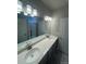 Bathroom featuring double sinks, a large mirror, and gray cabinets at 2277 Serenidad St, Brighton, CO 80601