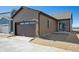 Newly constructed home featuring a brown exterior, a garage, a patio, and sliding glass doors at 2277 Serenidad St, Brighton, CO 80601