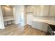 Open-concept kitchen with white cabinetry, modern hardware, and built-in desk area at 2277 Serenidad St, Brighton, CO 80601