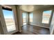 Bright living room with large windows and wood-look floors, offering natural light and an open atmosphere at 2277 Serenidad St, Brighton, CO 80601