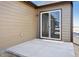 Outdoor patio area featuring a sliding glass door, exterior lighting, and concrete flooring at 2277 Serenidad St, Brighton, CO 80601