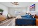 Comfortable bedroom featuring a ceiling fan, a large window, and hardwood flooring at 5670 Pinto Valley St, Parker, CO 80134