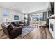 Cozy living room area featuring a fireplace, comfortable leather seating, and natural light at 5670 Pinto Valley St, Parker, CO 80134