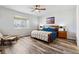 Cozy main bedroom featuring a ceiling fan, a large window, and hardwood floors at 5670 Pinto Valley St, Parker, CO 80134
