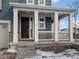 Covered front porch with white columns and dark brown door at 3260 Jonquil St, Castle Rock, CO 80109