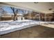 View from covered patio of the fenced backyard covered in snow and utility shed at 80 Ingalls St, Lakewood, CO 80226