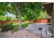 Backyard with mature trees, fence, small patio and landscaping at 8563 Redstone St, Highlands Ranch, CO 80126
