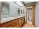 Bathroom with double sinks, wood cabinets, framed mirrors, and an adjoining toilet and shower room at 8563 Redstone St, Highlands Ranch, CO 80126