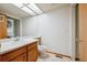 Well-lit bathroom features a sink, toilet, mirror, and a conveniently located stacked washer and dryer at 8563 Redstone St, Highlands Ranch, CO 80126
