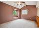 Bedroom with brown walls and carpet, complemented by a ceiling fan and arched window at 8563 Redstone St, Highlands Ranch, CO 80126