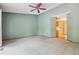 Bedroom with neutral carpet, a ceiling fan, and an entrance to a small area with cabinets at 8563 Redstone St, Highlands Ranch, CO 80126