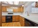 Kitchen with wooden cabinets, white countertops, and black appliances at 8563 Redstone St, Highlands Ranch, CO 80126