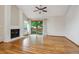 Inviting living room with hardwood floors, a ceiling fan, and a brick fireplace, perfect for relaxation at 8563 Redstone St, Highlands Ranch, CO 80126
